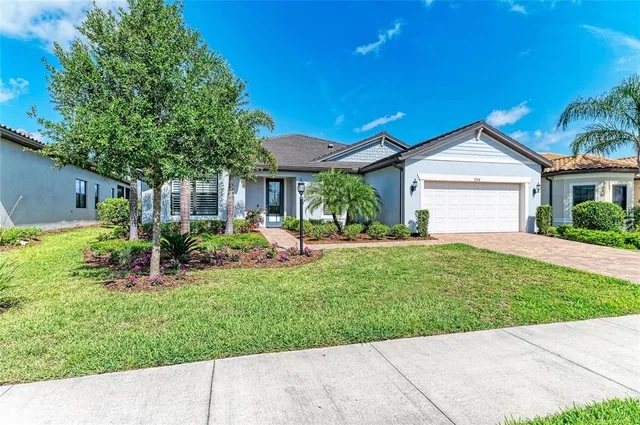 a front view of a house with a yard and potted plants