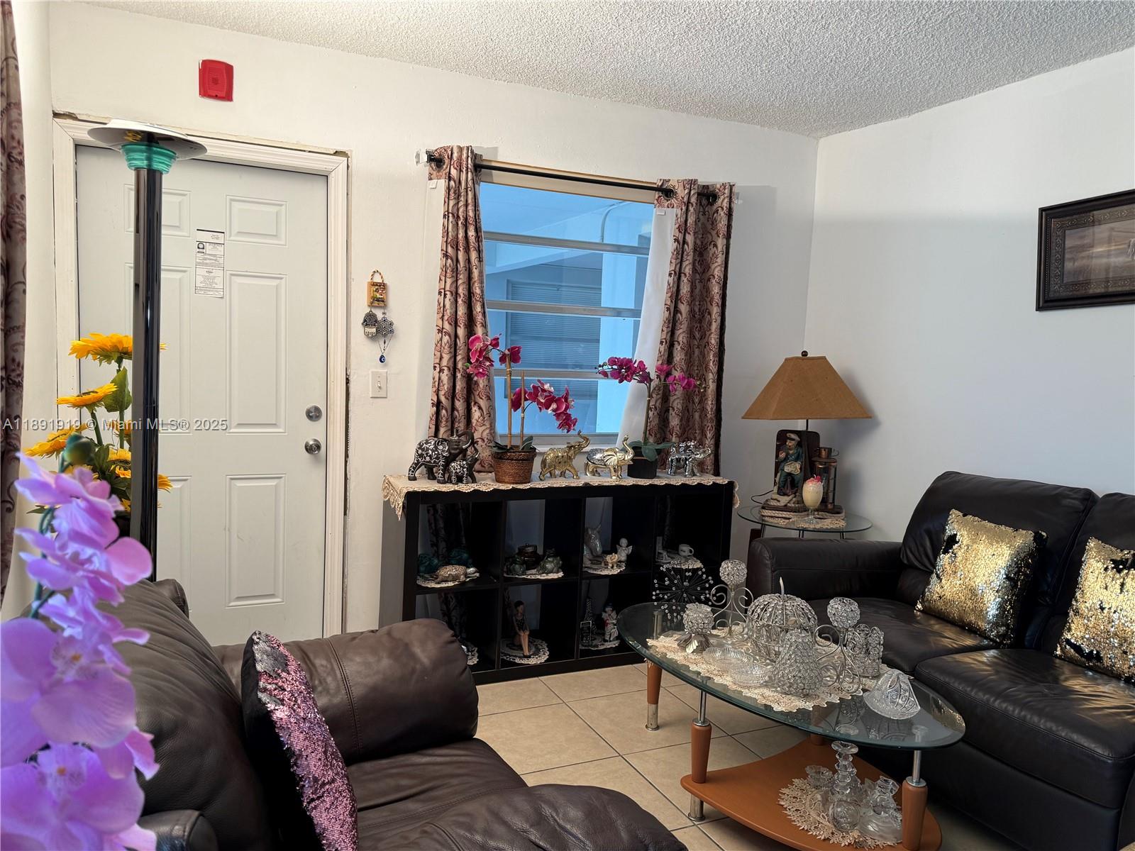 1100 Northeast 1st Court, Unit 120 Hallandale Beach, FL 33009 - Photo 11 of 45 a living room with furniture and a fireplace