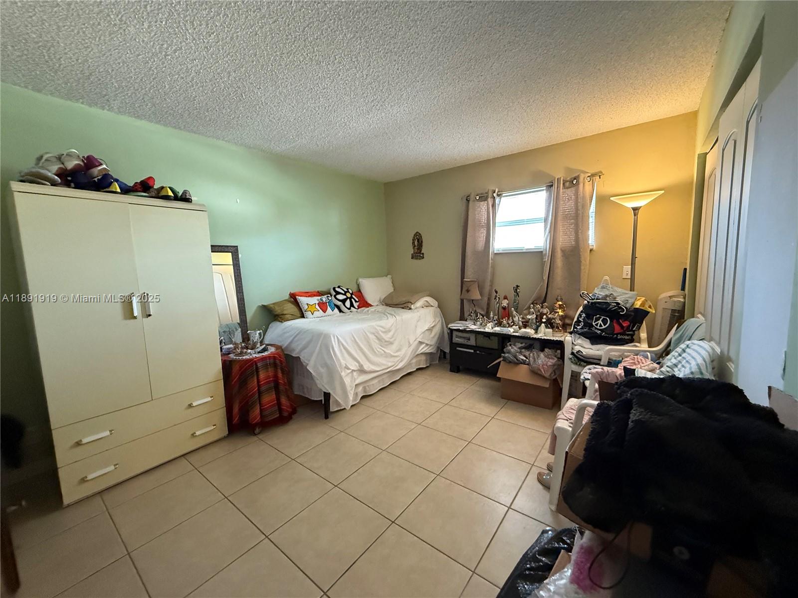 1100 Northeast 1st Court, Unit 120 Hallandale Beach, FL 33009 - Photo 15 of 45 a bed room with a bed and a mirror