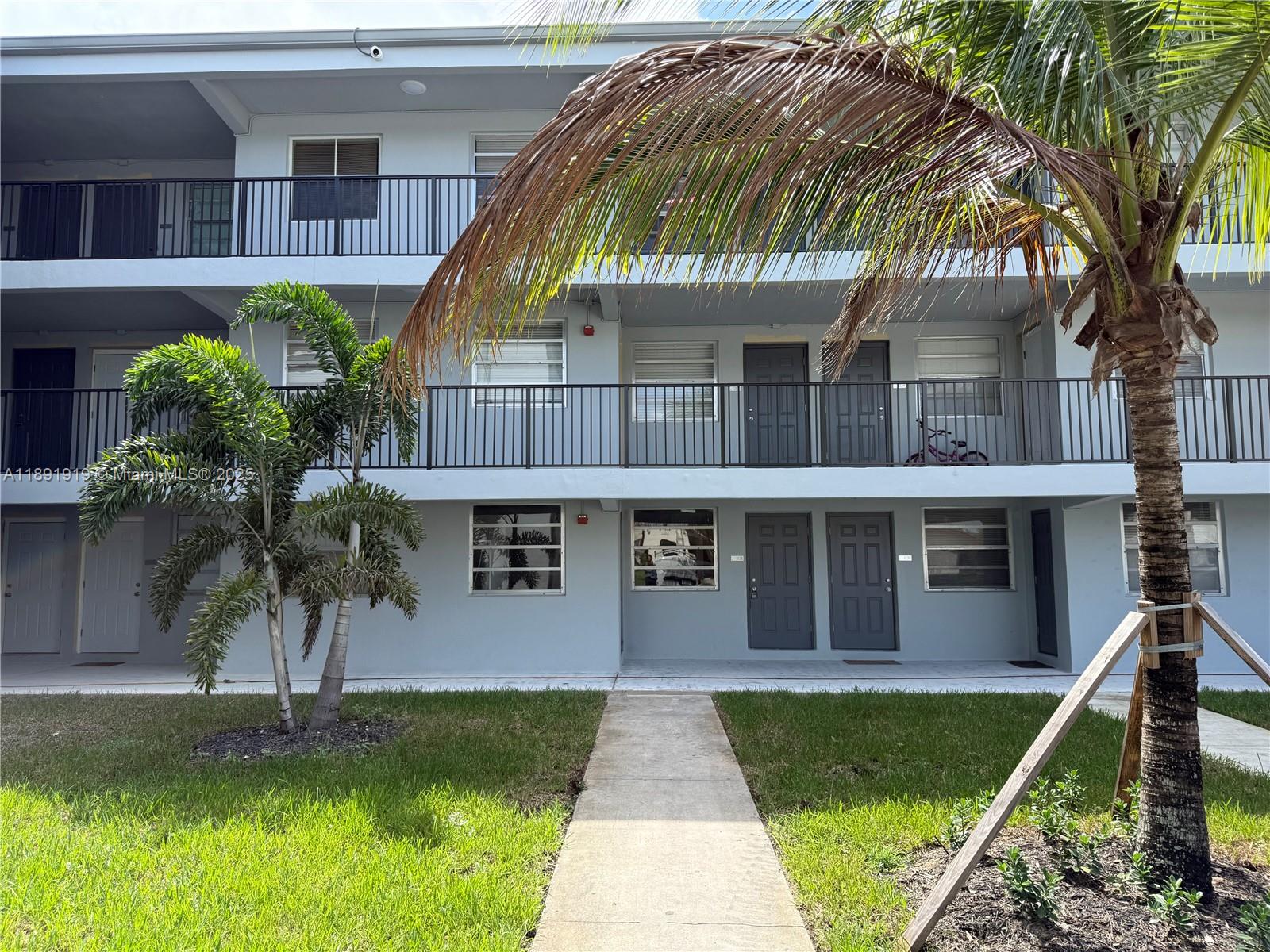 1100 Northeast 1st Court, Unit 120 Hallandale Beach, FL 33009 - Photo 25 of 45 a front view of a house with a garden
