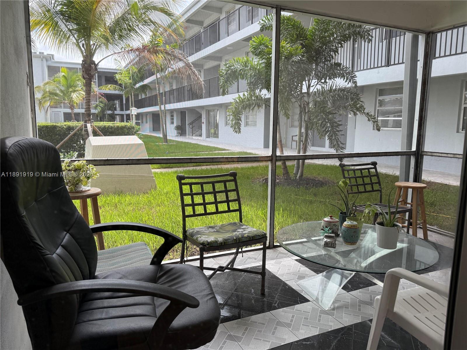 1100 Northeast 1st Court, Unit 120 Hallandale Beach, FL 33009 - Photo 30 of 45 a view of a chairs and table in patio