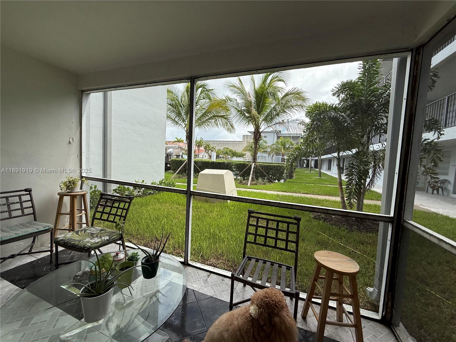 1100 Northeast 1st Court, Unit 120 Hallandale Beach, FL 33009 - Photo 34 of 45 a living room with a floor to ceiling window and wooden floor