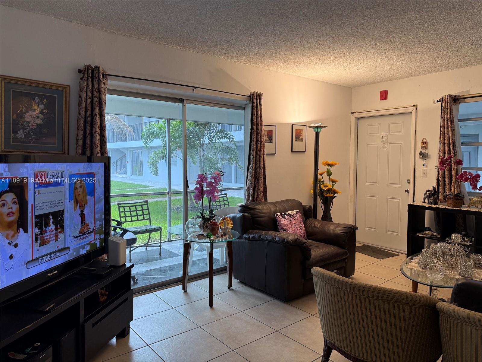 1100 Northeast 1st Court, Unit 120 Hallandale Beach, FL 33009 - Photo 38 of 45 a living room with furniture and a flat screen tv