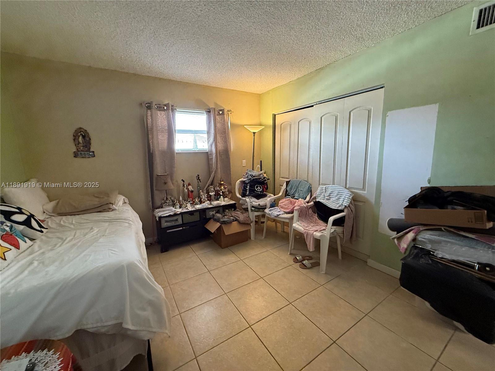 1100 Northeast 1st Court, Unit 120 Hallandale Beach, FL 33009 - Photo 39 of 45 a bed room with a bed and a couch