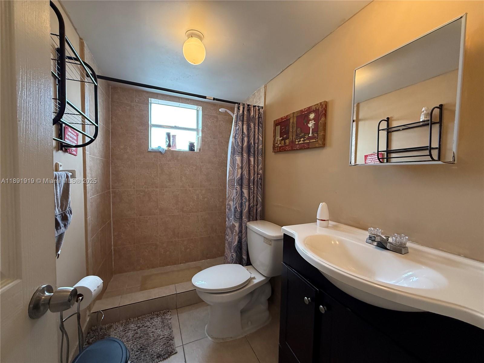 1100 Northeast 1st Court, Unit 120 Hallandale Beach, FL 33009 - Photo 40 of 45 a bathroom with a sink a toilet and shower