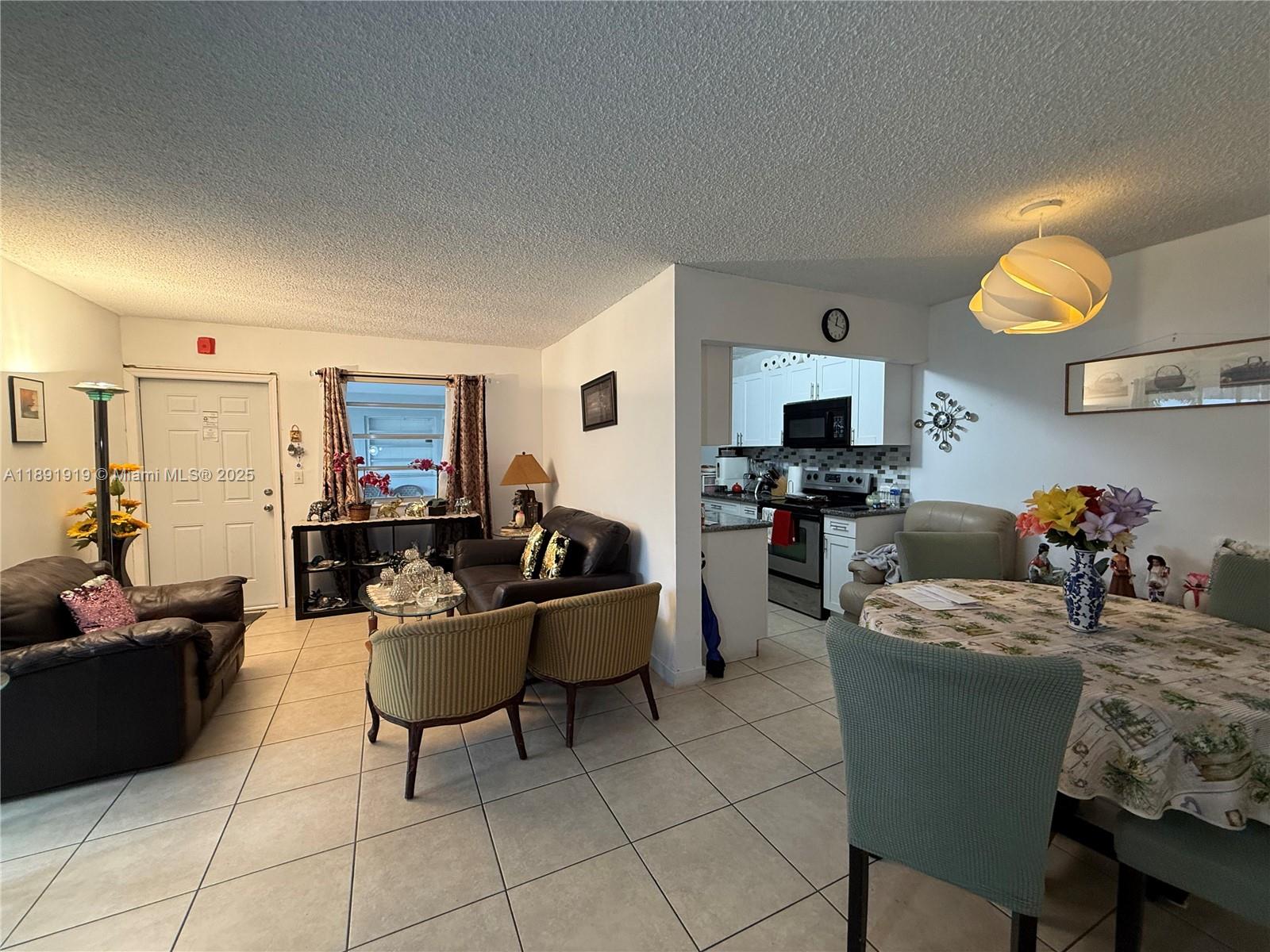 1100 Northeast 1st Court, Unit 120 Hallandale Beach, FL 33009 - Photo 7 of 45 a living room with furniture and a flat screen tv