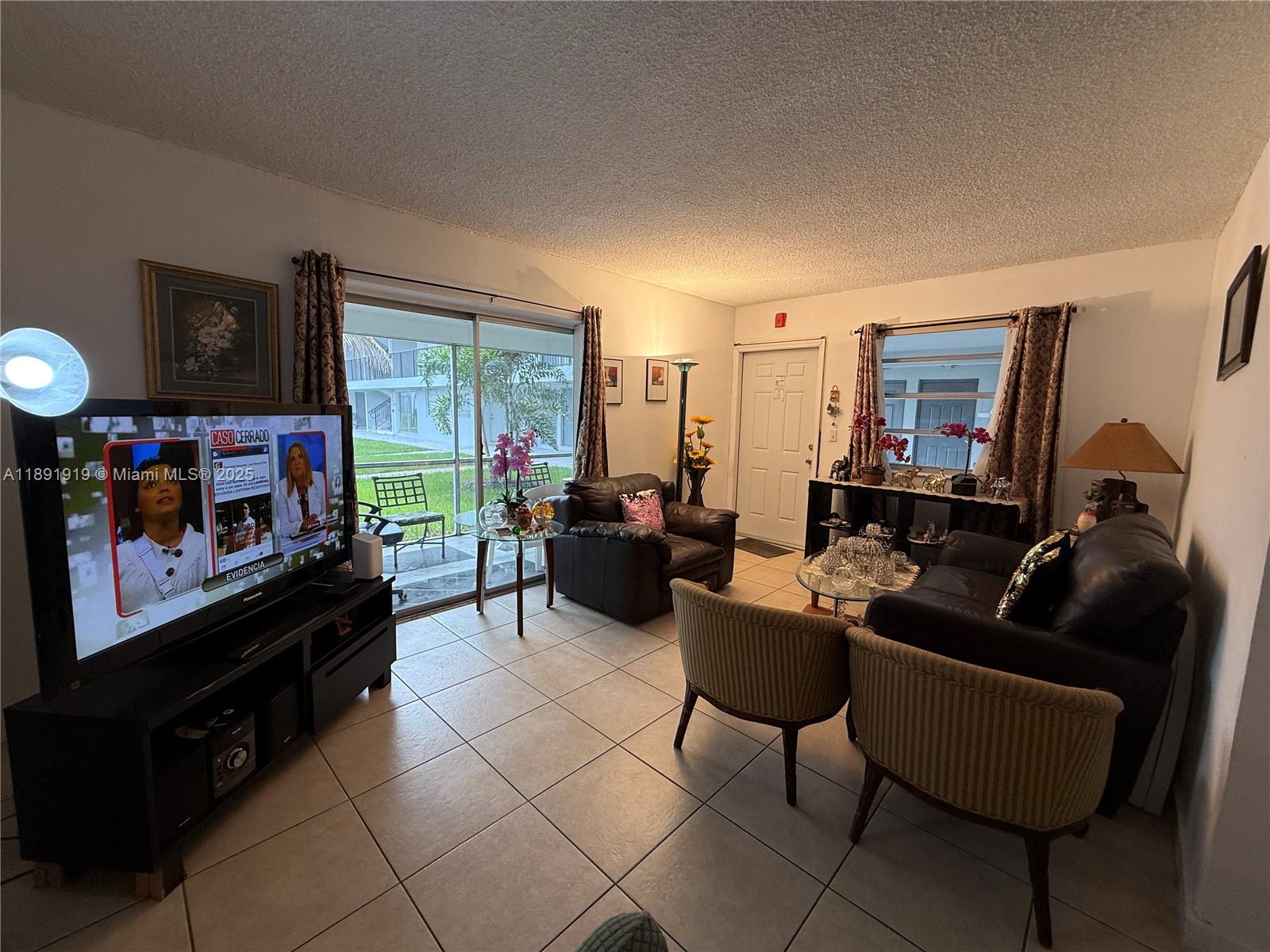 1100 Northeast 1st Court, Unit 120 Hallandale Beach, FL 33009 - Photo 8 of 45 a living room with furniture and a flat screen tv