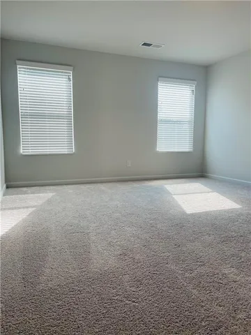 a view of an empty room with window and bathroom