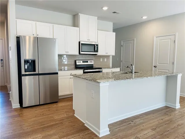 a kitchen with granite countertop a refrigerator and a sink
