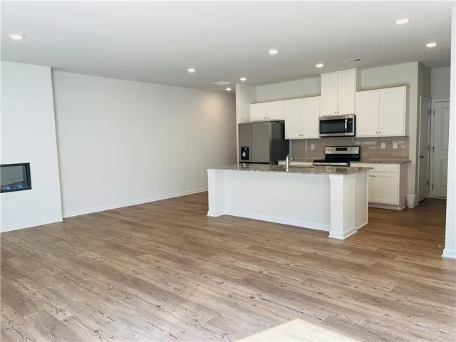 a kitchen with stainless steel appliances a stove top oven a sink and a refrigerator