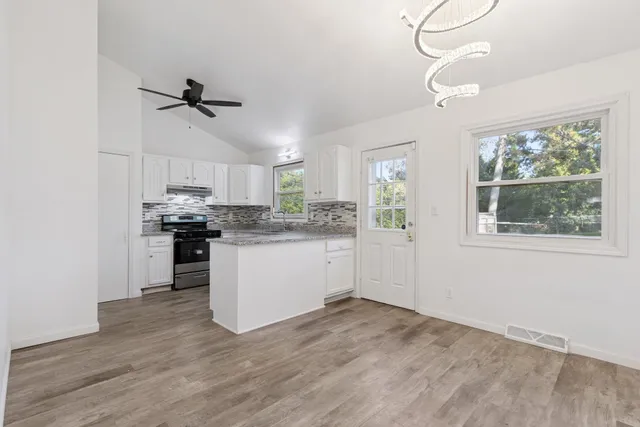 a kitchen with kitchen island white cabinets and window