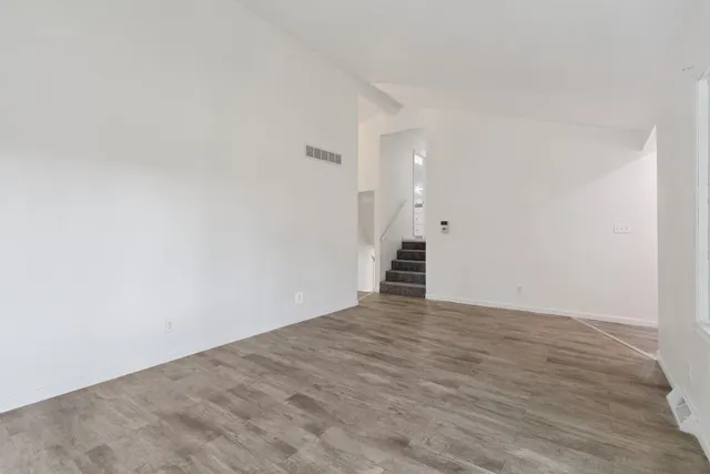 a view of an empty room with wooden floor