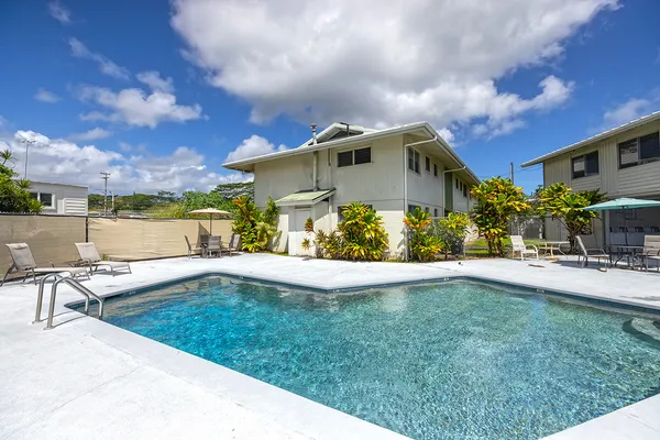 a view of a house with backyard and sitting area