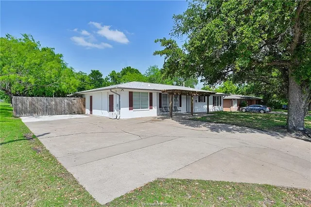 a front view of a house with a yard and trees