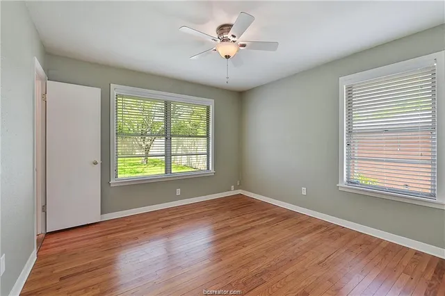 a view of a room with wooden floor and a window