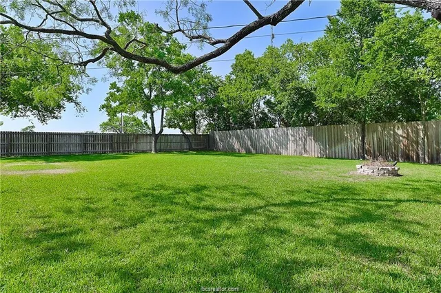a small pool with a yard and wooden fence