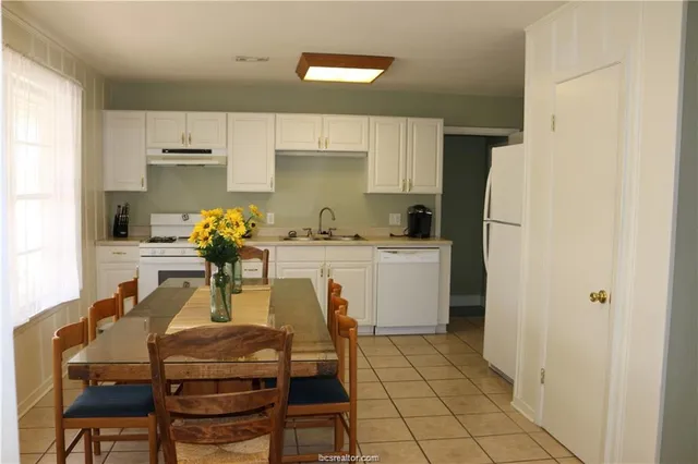 a white kitchen with a sink appliances and cabinets