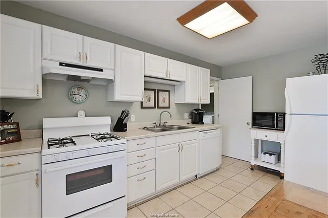 a kitchen with granite countertop cabinets and white appliances