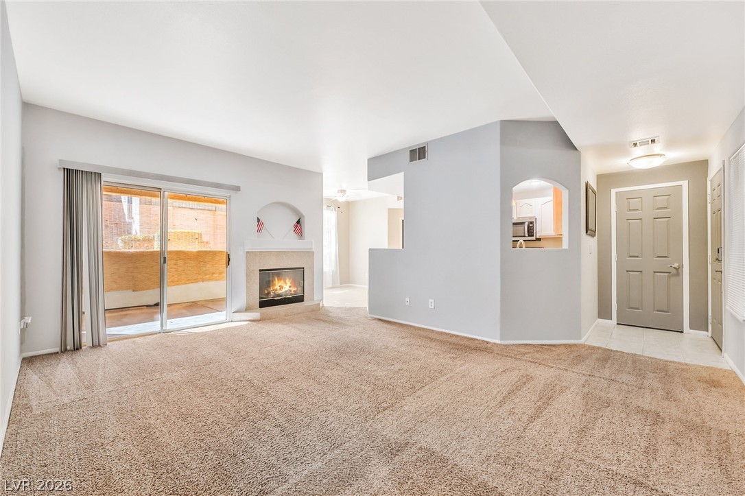 2050 West Warm Springs Road, Unit 2411 Henderson, NV 89014 - Photo 9 of 37 A cozy fireplace and glass sliding doors enhance this welcoming living space.