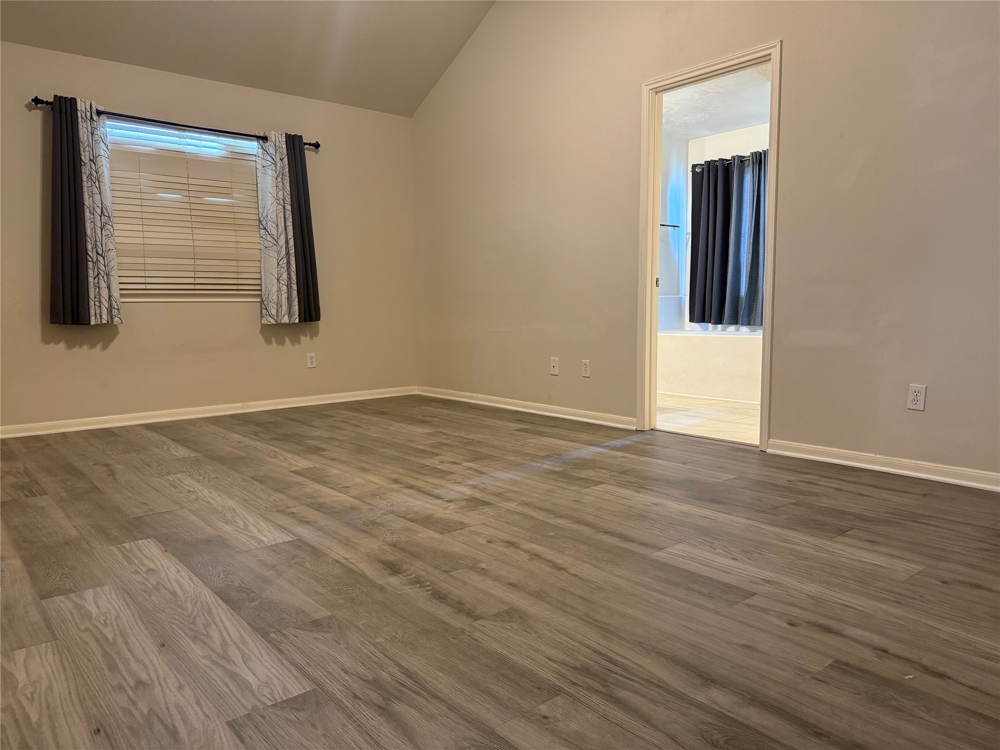 13715 Audra Lane Houston, TX 77083 - Photo 11 of 25 a view of an empty room with wooden floor and a window