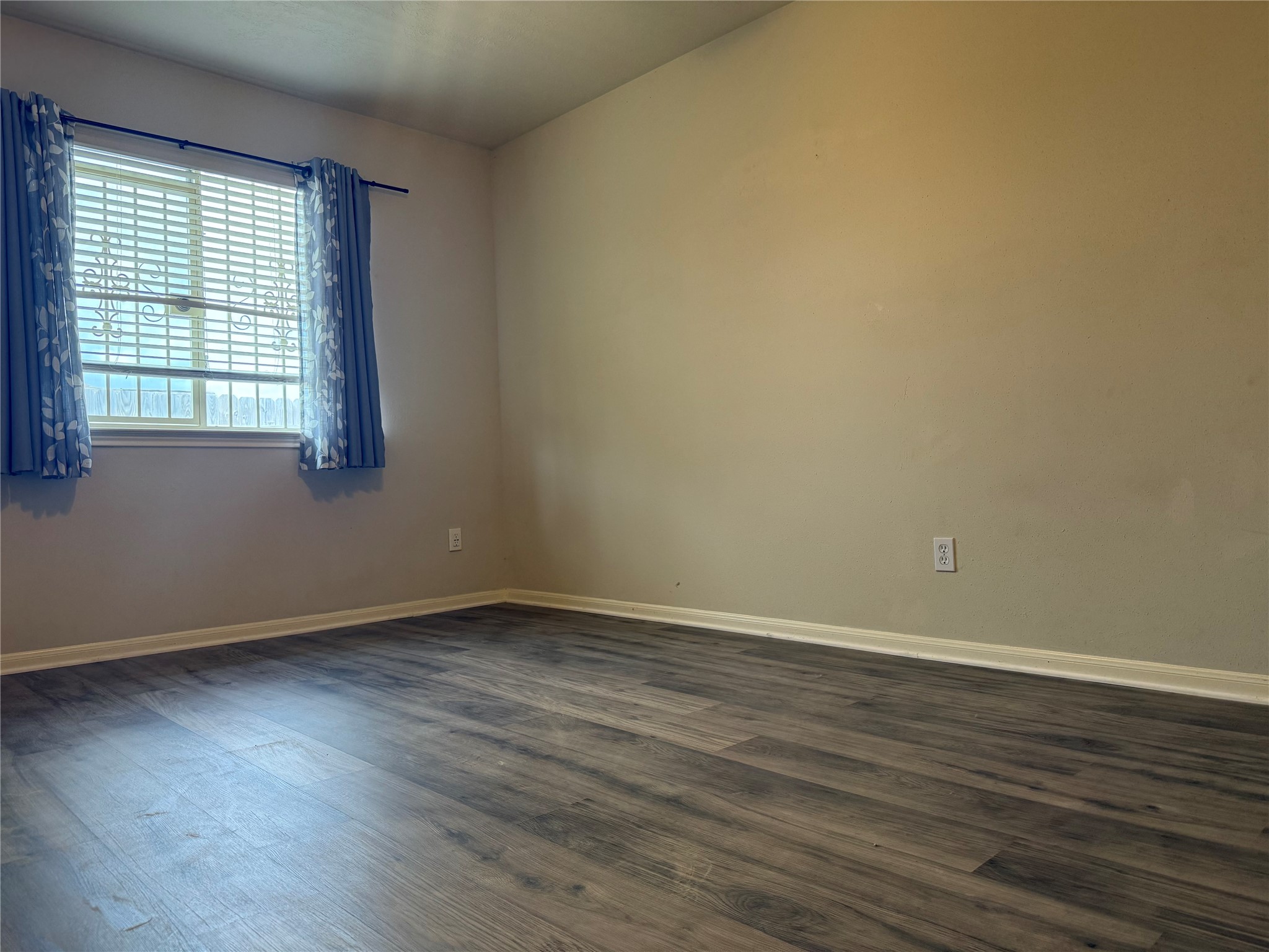 13715 Audra Lane Houston, TX 77083 - Photo 19 of 25 a view of an empty room with wooden floor and a window