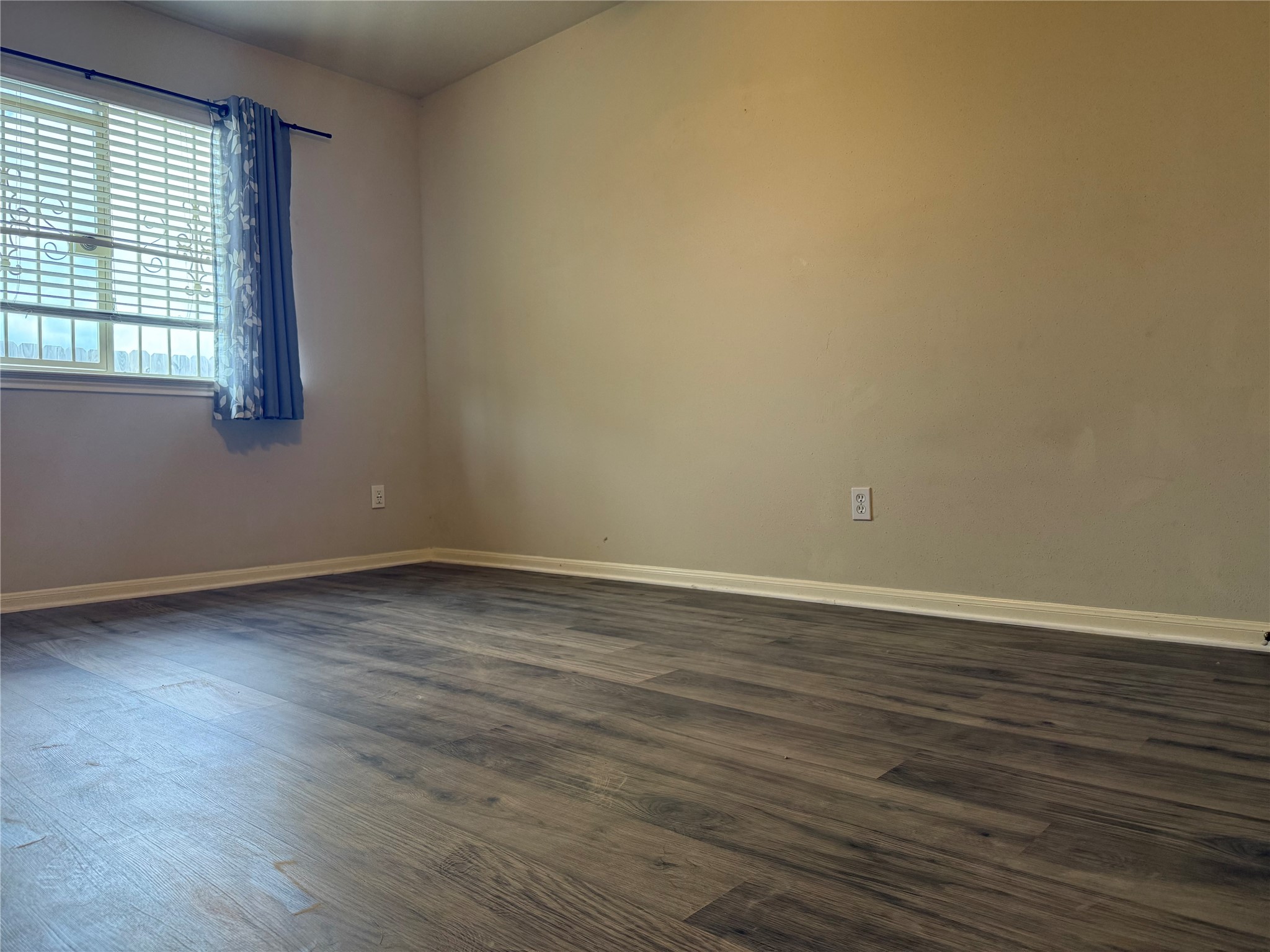 13715 Audra Lane Houston, TX 77083 - Photo 20 of 25 a view of an empty room with wooden floor and a window
