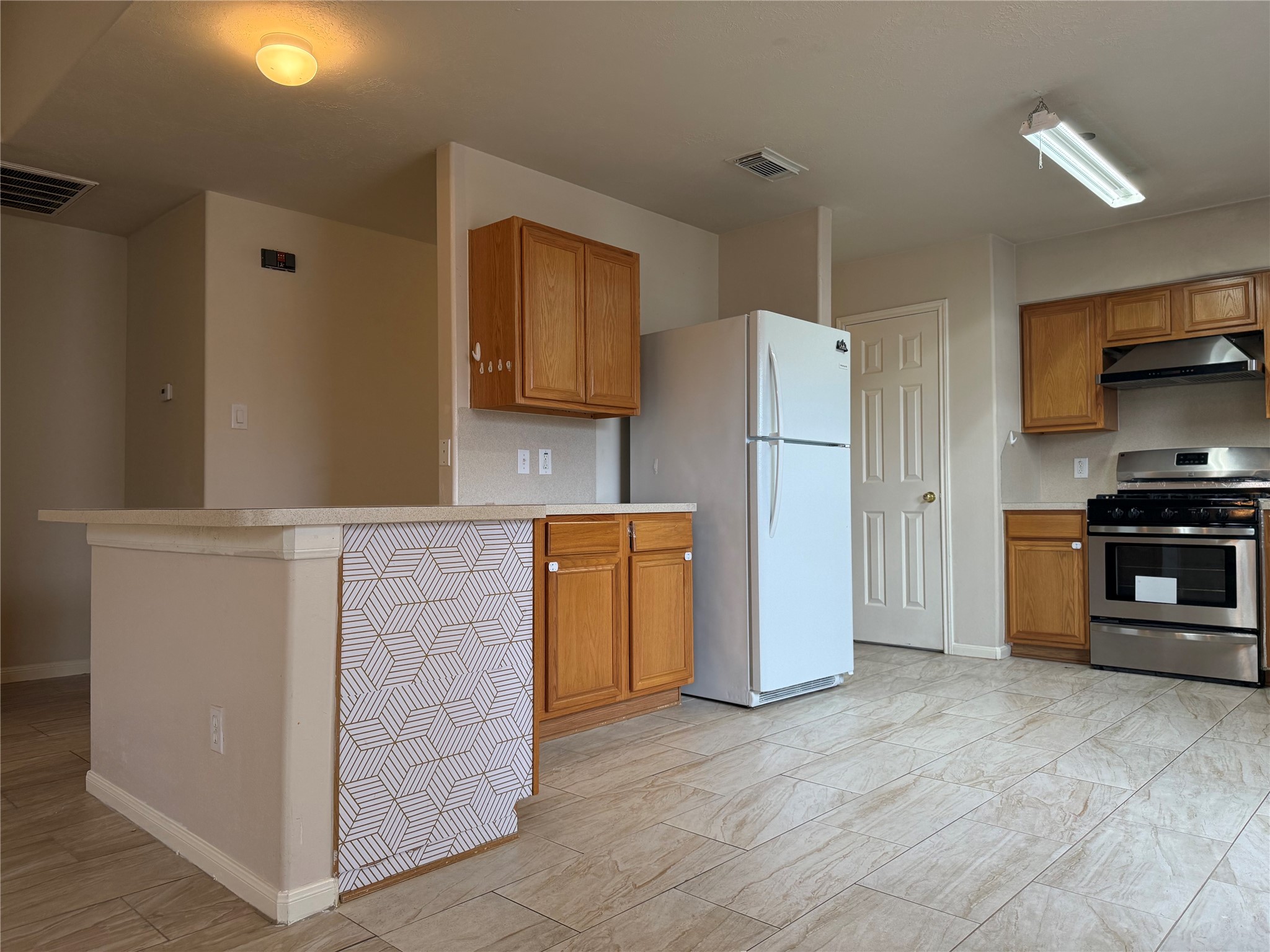 13715 Audra Lane Houston, TX 77083 - Photo 7 of 25 a kitchen with a refrigerator and a stove top oven