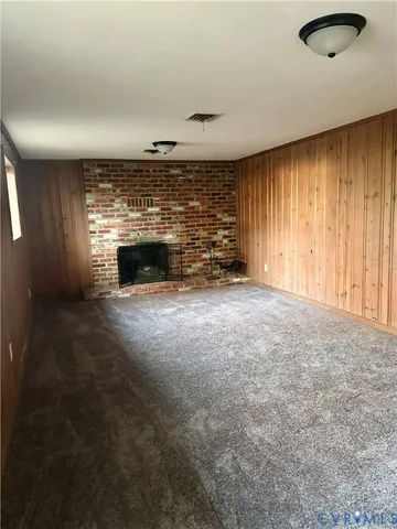 an empty room with windows and fireplace
