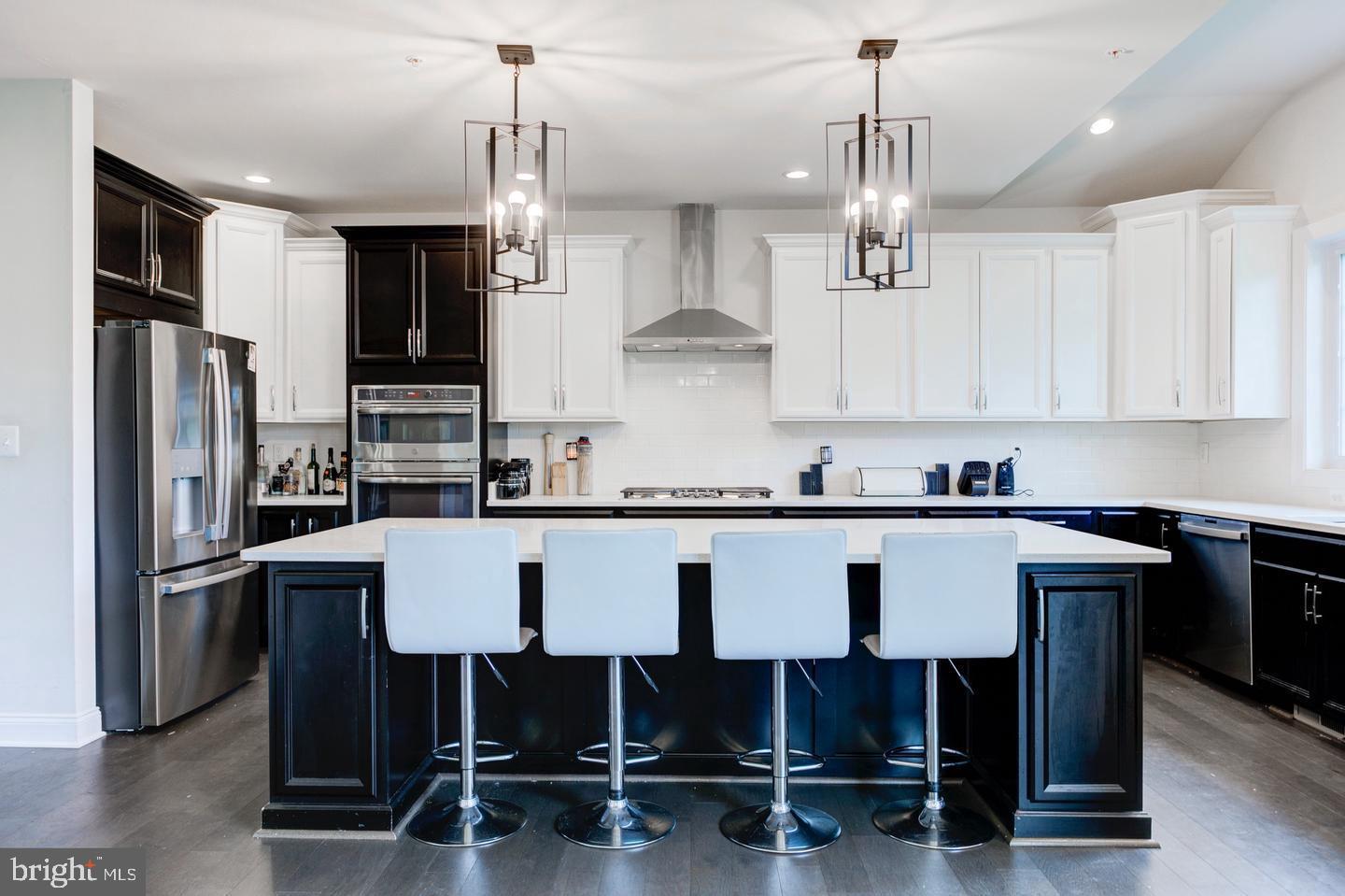 4902 Bridle Ridge Road Upper Marlboro, MD 20772 - Photo 6 of 20 a kitchen with a table chairs refrigerator microwave and cabinets