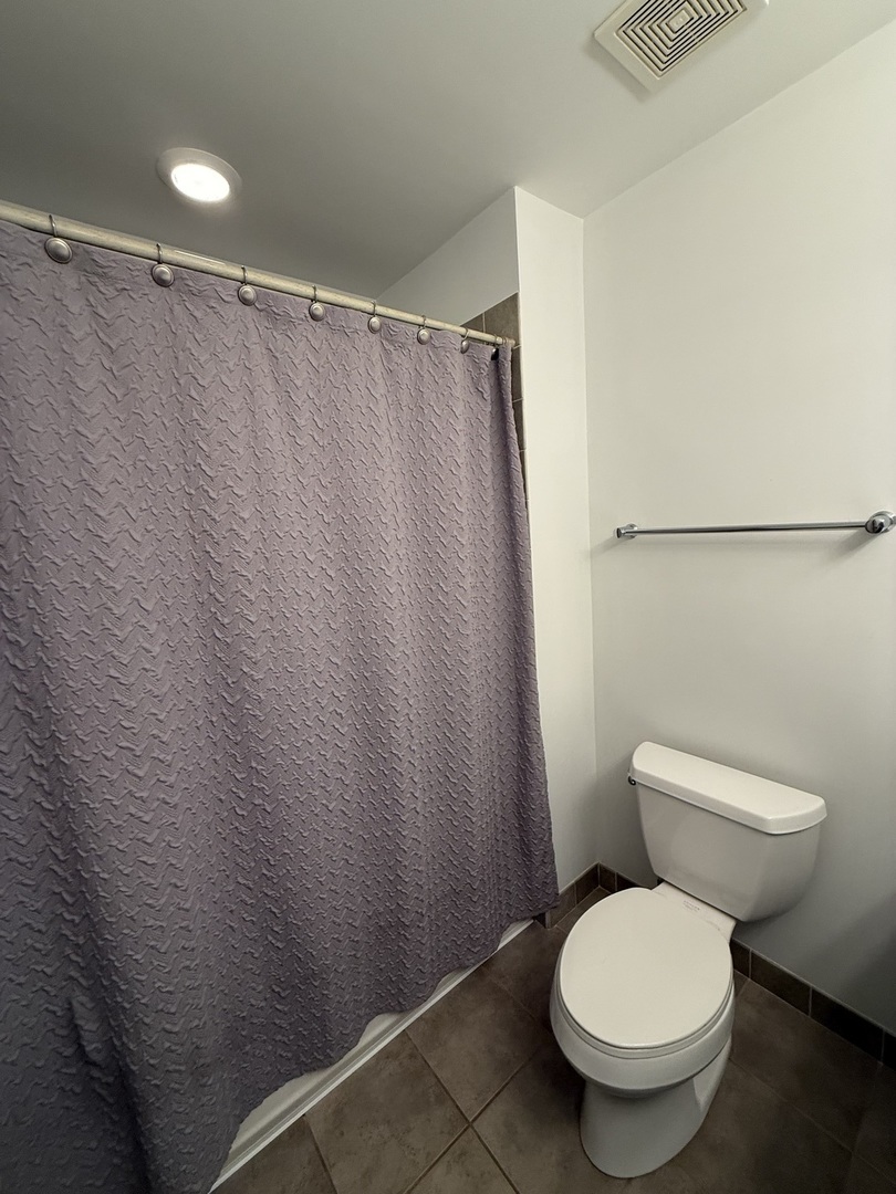 222 South Racine Avenue, Unit 207 Chicago, IL 60607 - Photo 15 of 29 a white toilet sitting next to a shower curtain