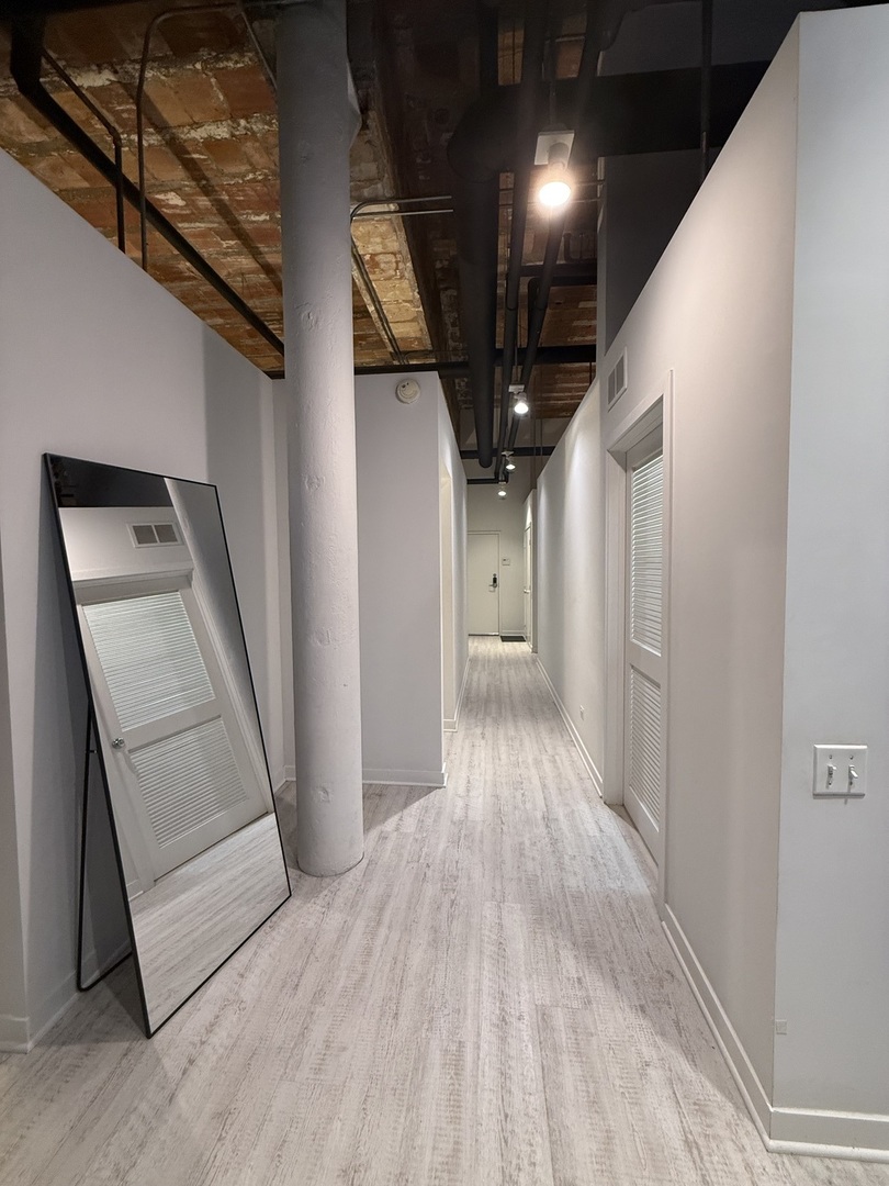 222 South Racine Avenue, Unit 207 Chicago, IL 60607 - Photo 18 of 29 a view of hallway with stairs and wooden floor