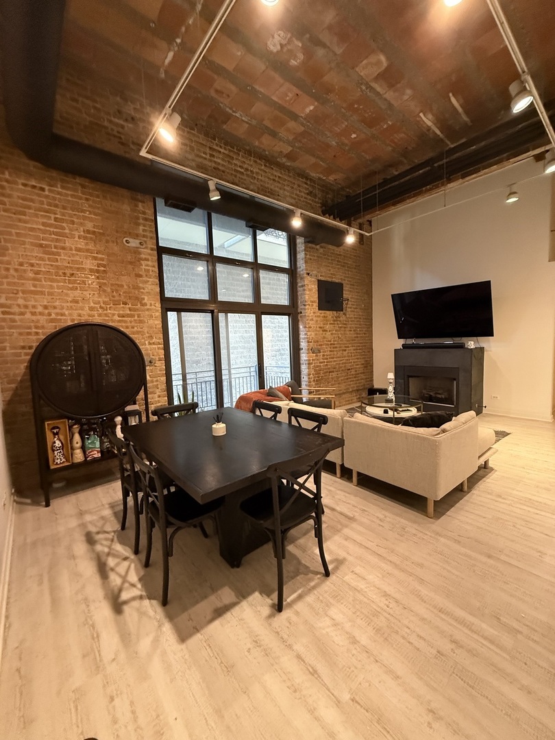 222 South Racine Avenue, Unit 207 Chicago, IL 60607 - Photo 5 of 29 a living room with furniture a flat screen tv and a fireplace