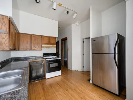 a kitchen with stainless steel appliances granite countertop a refrigerator stove and sink