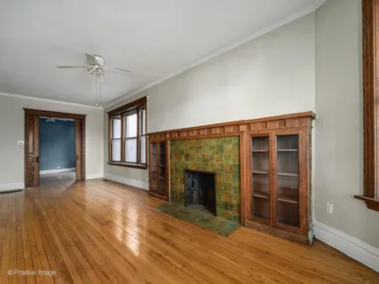 wooden floor fireplace and windows in an empty room
