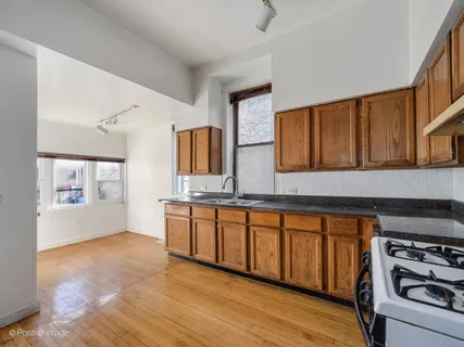a large kitchen with granite countertop a stove and a sink