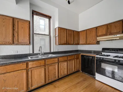 a kitchen with stainless steel appliances granite countertop a stove a sink and a microwave