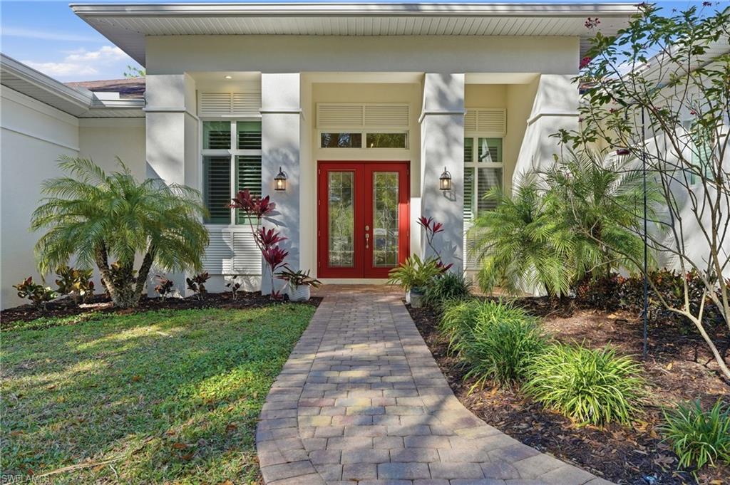3707 5th Avenue Southwest Naples, FL 34117 - Photo 2 of 45 View of exterior entry with lead glass front doors, paver walkway and landscaping
