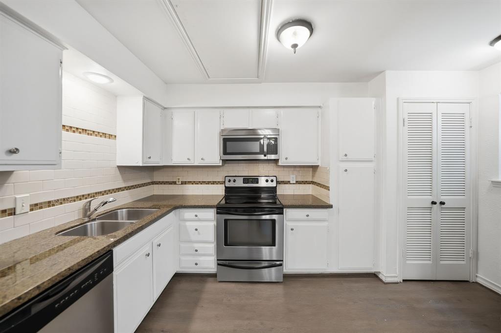 2815 Welborn Street, Unit 101 Dallas, TX 75219 - Photo 10 of 29 Kitchen featuring white cabinetry, stainless steel appliances, granite-look countertops, subway tile backsplash with decorative accent, and a dual basin sink