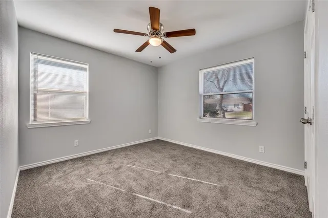 an empty room with chandelier fan