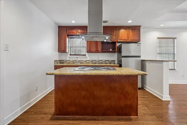 a view of kitchen with kitchen island a sink wooden floor and black appliances