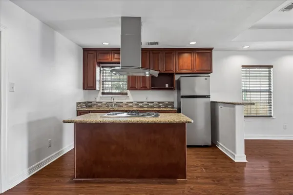 a kitchen with stainless steel appliances granite countertop a stove a refrigerator and a microwave