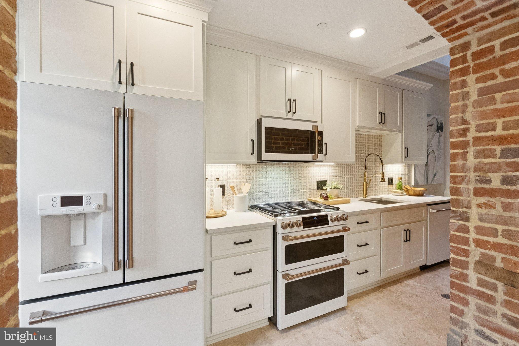 1514 R Street Northwest Washington, DC 20009 - Photo 65 of 84 a kitchen with stainless steel appliances a stove microwave and cabinets