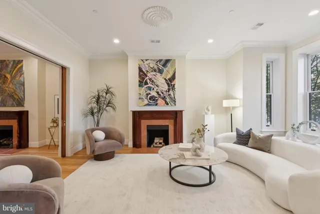 a living room with furniture a fireplace and a large window