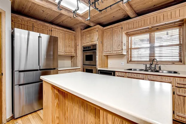 a kitchen with stainless steel appliances granite countertop a sink dishwasher a stove a refrigerator with a dining table and chairs