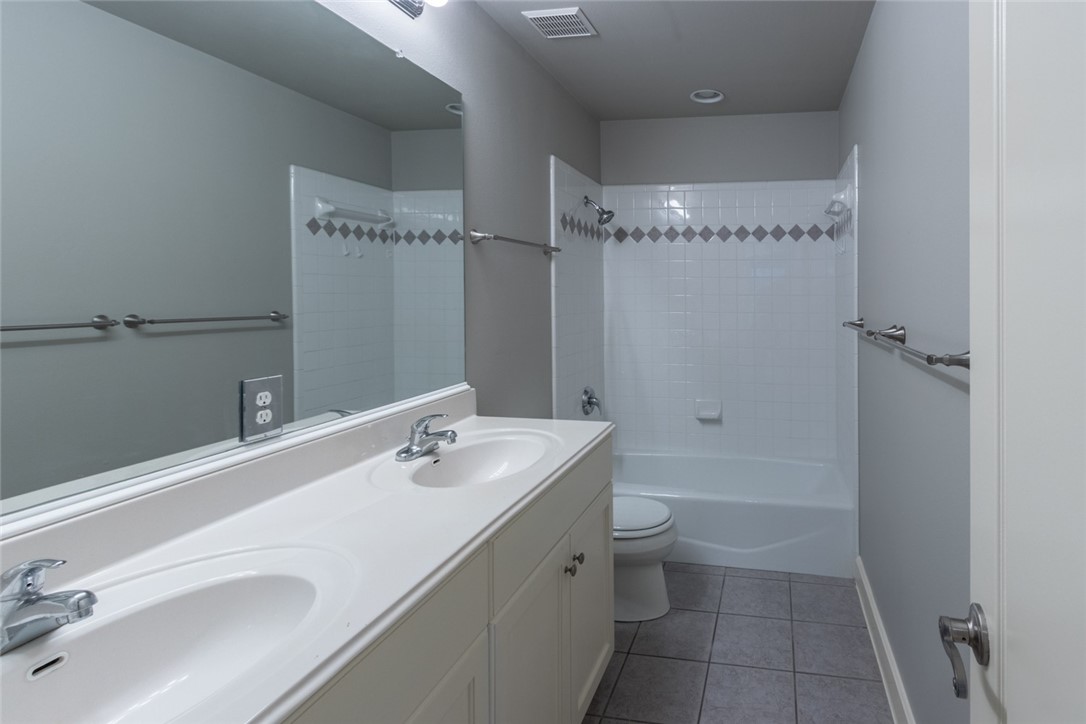 306 East 34th Street, Unit A Austin, TX 78705 - Photo 18 of 28 a bathroom with a granite countertop sink a toilet and shower
