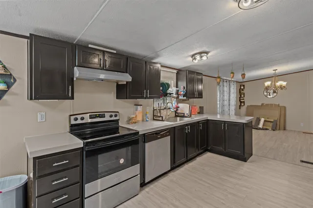 a kitchen with a stove sink and cabinets