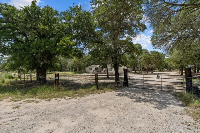 a view of a yard with wooden fence