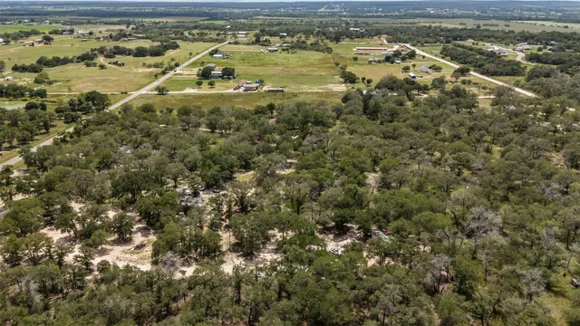 an aerial view of residential houses with outdoor space and trees