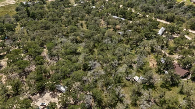 an aerial view of residential houses with outdoor space and trees