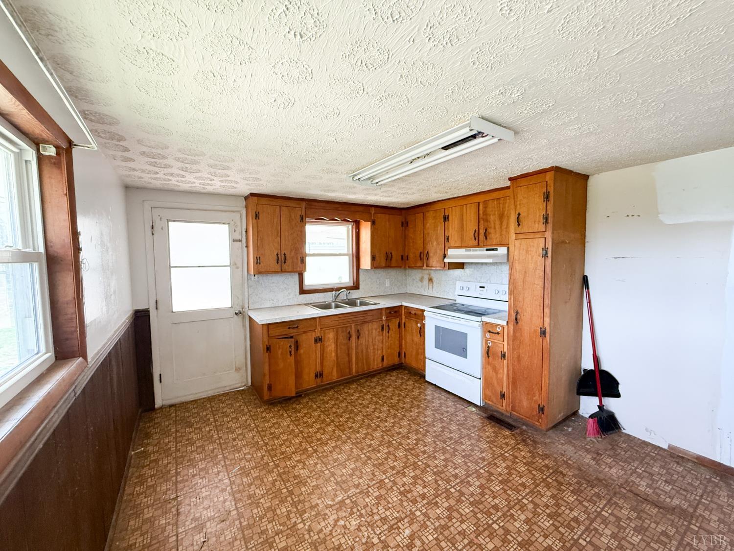 6218 Old Evergreen Road Appomattox, VA 24522 - Photo 5 of 11 a kitchen with stainless steel appliances a large counter top a stove a sink and a refrigerator